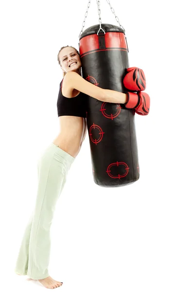 Atletische vrouw knuffelen een bokszak — Stockfoto