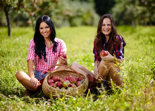 Vackra kvinnor som tar en tugga av ett äpple — Stockfoto