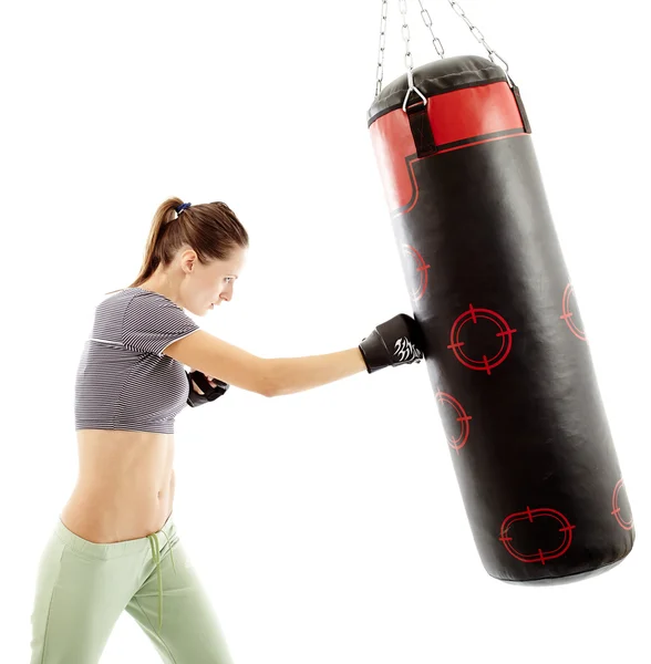 Mujer atlética golpeando el saco de boxeo — Foto de Stock