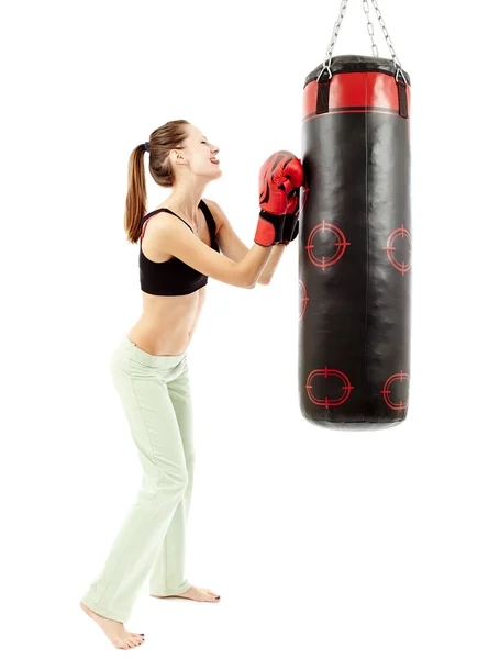 Mujer atlética divirtiéndose y tirando de caras a un saco de boxeo —  Fotos de Stock