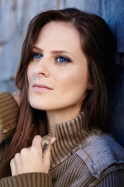 Beautiful woman leaning on a cabin log — Stock Photo, Image