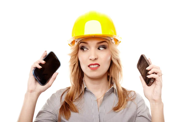 Engenheira estressada usando dois telefones celulares ao mesmo tempo — Fotografia de Stock