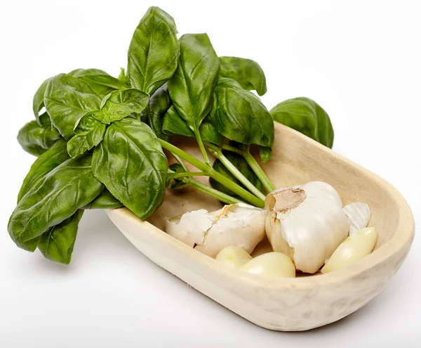Fresh garlic and basil in a wooden bowl — Stock Photo, Image
