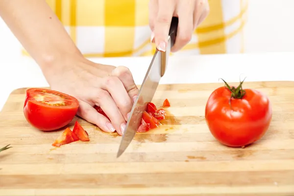 Slicing the tomato on a wooden board — Stock Photo, Image