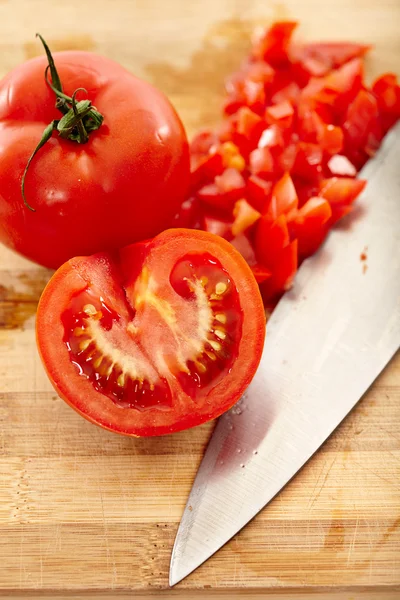 Freshly chopped tomatoes on a wooden board — Stok fotoğraf