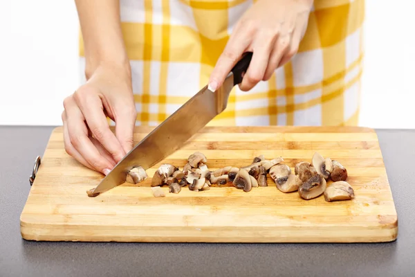 Woman cook's hands chopping mushrooms on a wooden board — Stock Photo, Image