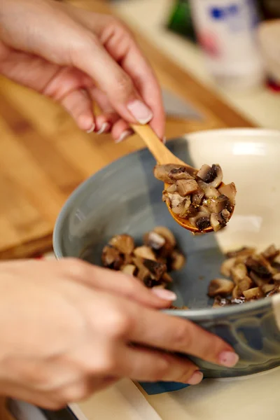 Las manos de la mujer cocinera preparando setas en un tazón de cerámica — Foto de Stock