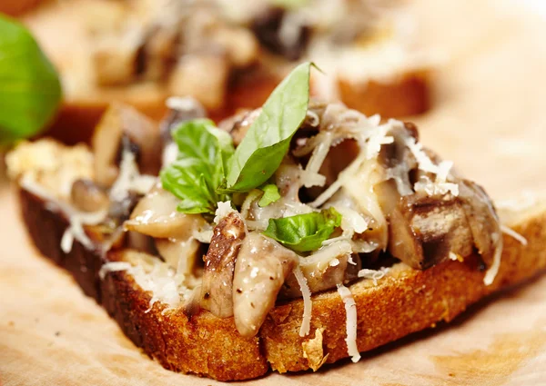 Bruschettas de cogumelos frescos em uma tábua de madeira — Fotografia de Stock