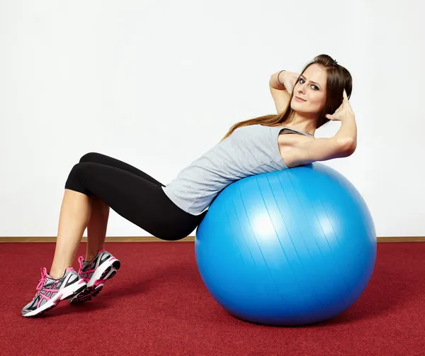 Chica haciendo abdominales crujidos en gimnasio pelota — Foto de Stock