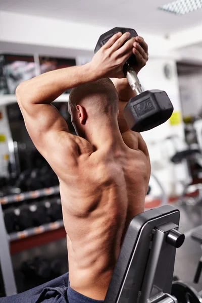 Athletic man working with heavy dumbbell — Stock Photo, Image