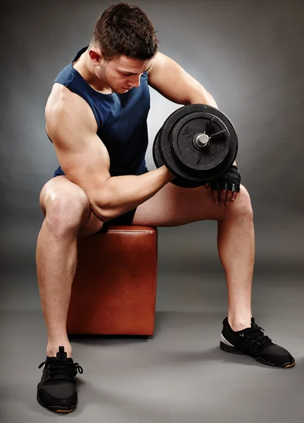 Athletic man working with heavy dumbbells — Stock Photo, Image