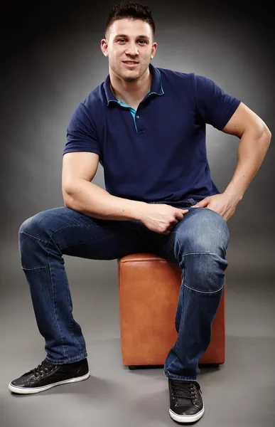 Handsome young man sitting down — Stock Photo, Image