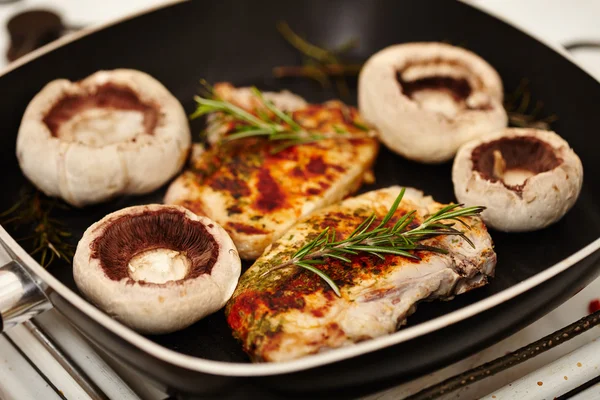 Chuletas de cerdo fritas y champiñones en la sartén — Foto de Stock