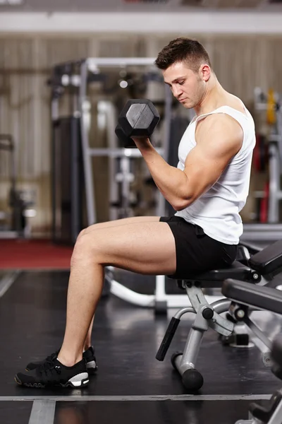 Yakışıklı erkek spor salonunda ağır dumbell ile çalışma — Stok fotoğraf