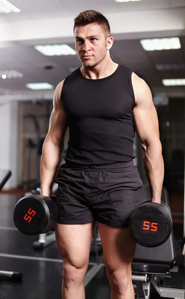 Athletic man holding heavy dumbbells — Stock Photo, Image