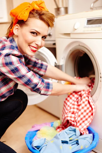 Домохозяйка кладет белье в стиральную машину — стоковое фото
