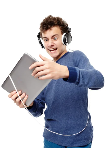 Angry teenager listening to music at headphones while looking at — Stock Photo, Image