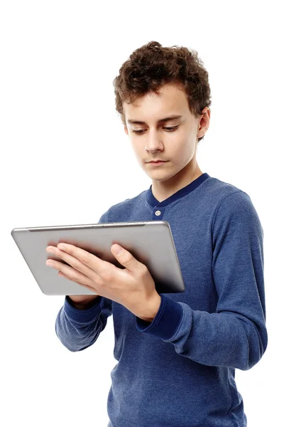 Smart Teenager arbeitet an einem Tablet, das er in der Hand hält — Stockfoto