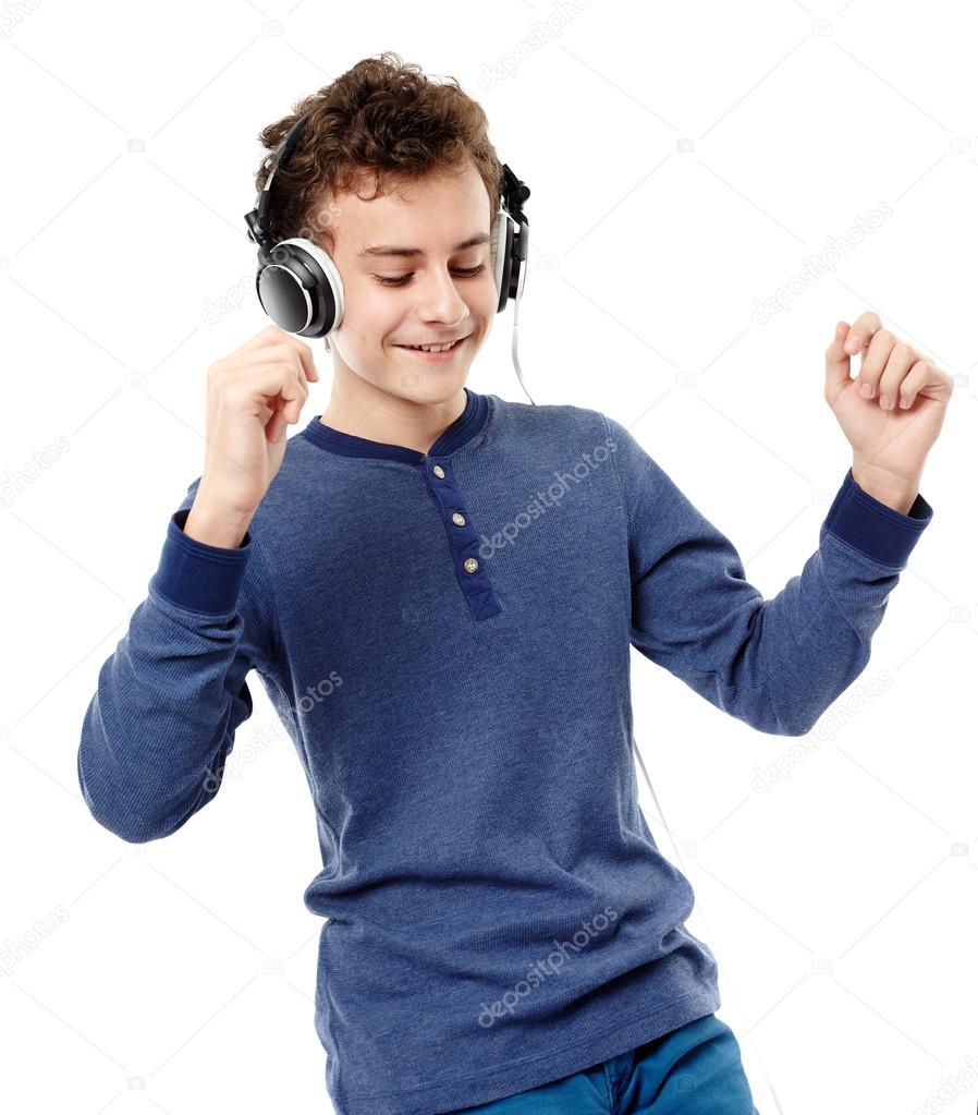 Teenager dancing and listening to music at headphones
