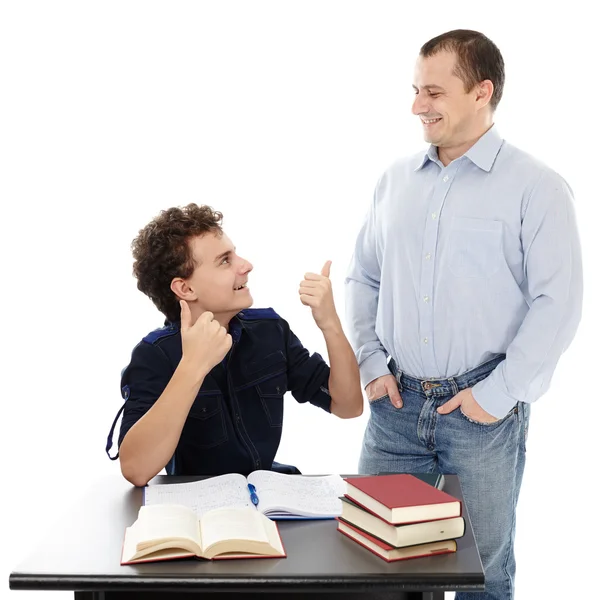 Glücklicher Sohn sitzt an seinem Schreibtisch und drückt seinem Vater die Daumen — Stockfoto