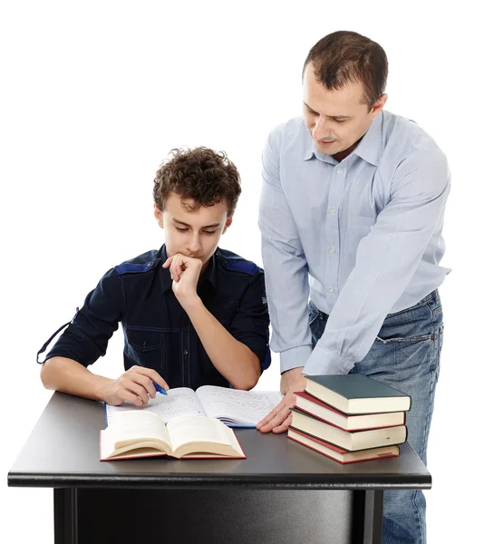 Vater steht am Schreibtisch seines Sohnes und hilft ihm bei den Hausaufgaben — Stockfoto