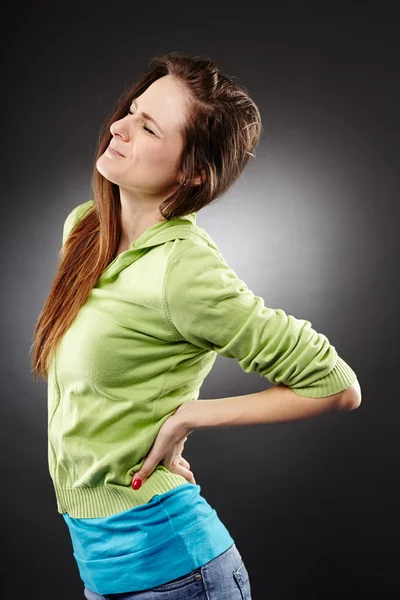 Young woman having a severe lumbar pain — Stock Image Young woman having a severe lumbar pain Royalty Free Stock Images
