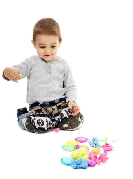 Kleiner Junge spielt mit Knetmasse — Stockfoto
