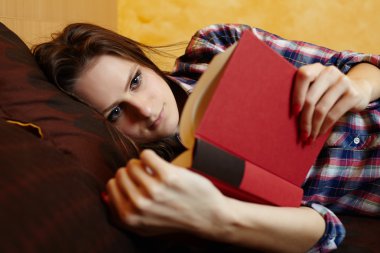 Genç Bayan yatakta kitap okuma