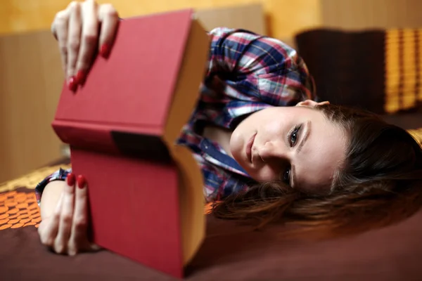 Giovane signora che legge un libro sul letto — Foto Stock