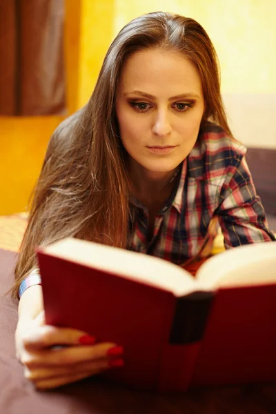 Mladá dáma, čtení knihy na postel — Stock fotografie