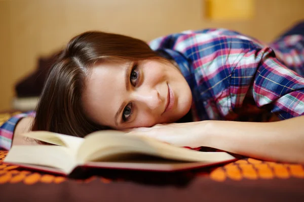 Jonge dame lezen van een boek op het bed — Stockfoto