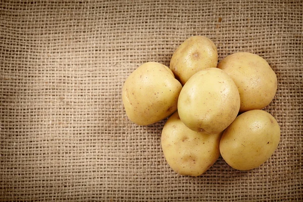 Patatas sobre un lienzo rústico — Foto de Stock