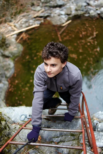 Adolescente menino escalando — Fotografia de Stock