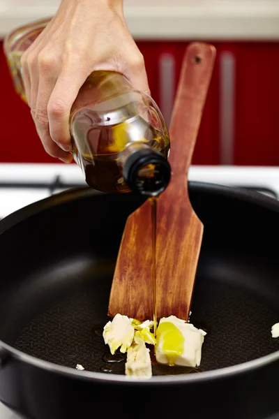 Pouring olive oil over melting butter — Stock Photo, Image