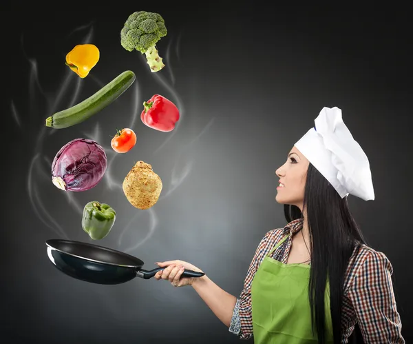 Skillful cook lady throwing veggies — Stock Photo, Image