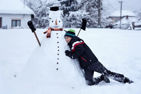 Adolescente construindo um boneco de neve — Fotografia de Stock