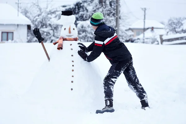 Tonåring bygga en snögubbe — Stockfoto