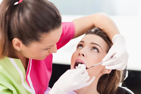 Woman dentist checking her patient's teeth — Stock Photo, Image