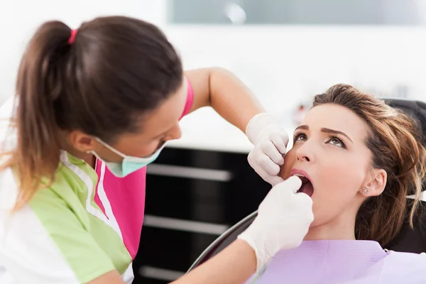 Donna dentista controllare i denti del suo paziente — Foto Stock