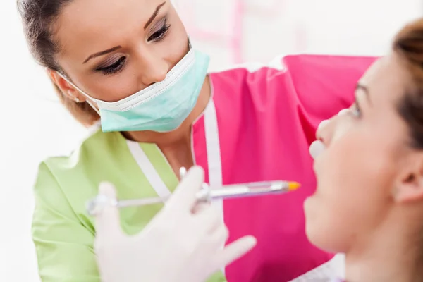 Mulher dentista dando a seu paciente uma injeção de anestesia — Fotografia de Stock