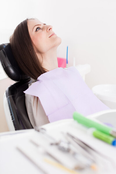  Woman patient at the dentist with instruments in the blurred fo