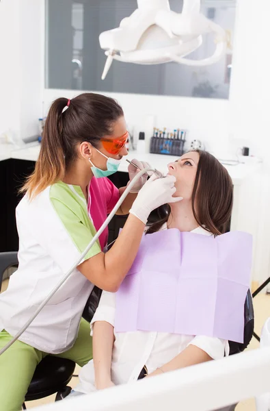 Mulher dentista trabalhando com o perfurador — Fotografia de Stock