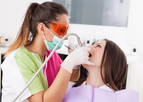 Mulher dentista trabalhando com o perfurador — Fotografia de Stock