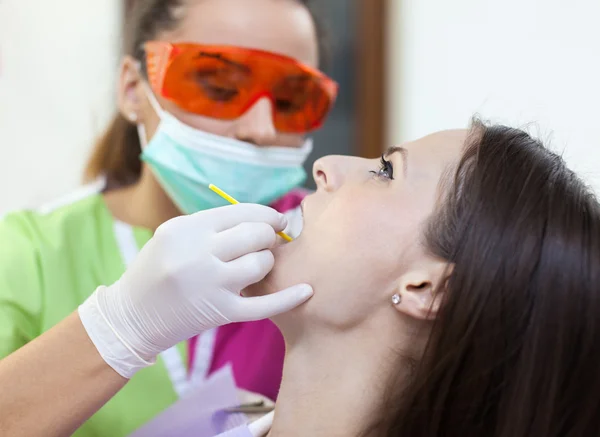 Mulher dentista verificando os dentes de seu paciente — Fotografia de Stock