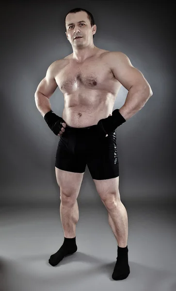 Shirtless athletic muscular man standing akimbo — Stock Photo, Image