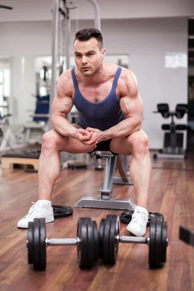 健壮的男人在健身房里的长凳上休息 — 图库照片