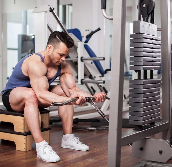 Sportlicher Mann stemmt im Fitnessstudio schwere Gewichte — Stockfoto