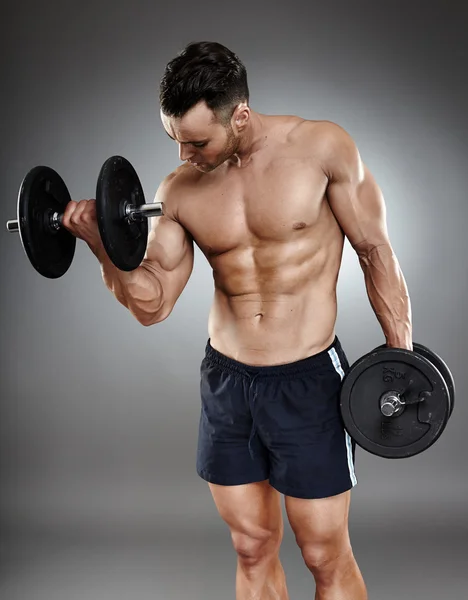 Athletic man working out with dumbbells — Stock Photo, Image