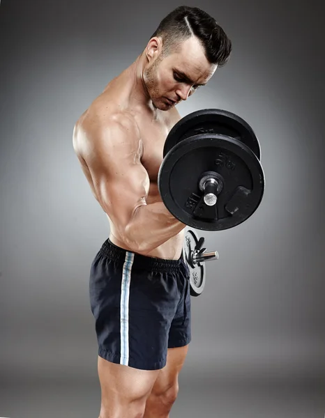 Athletic man working out with dumbbells — Stock Photo, Image