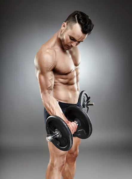 Athletic man working out with dumbbells — Stock Photo, Image